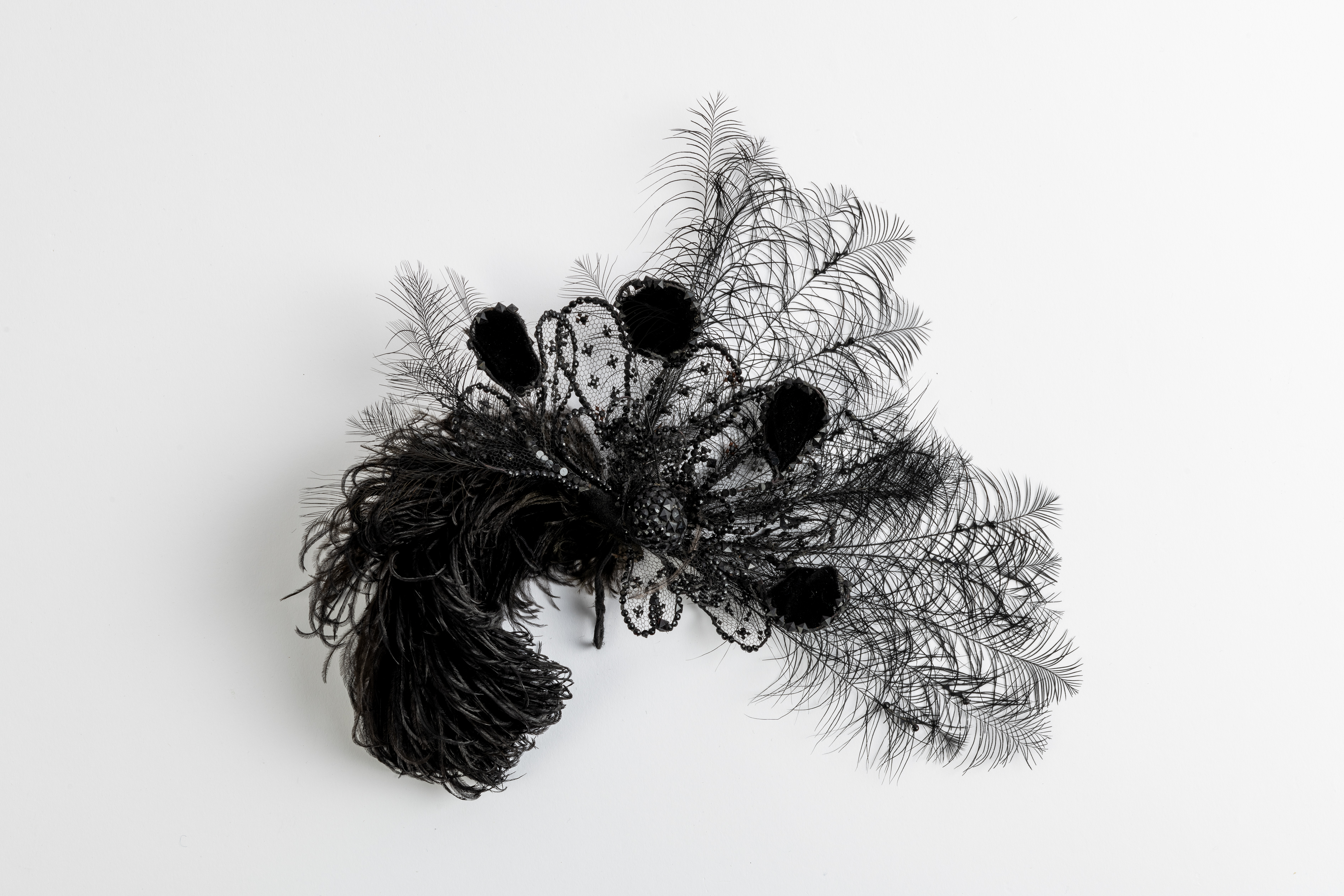 Hair ornament of black feathers and beads on velvet