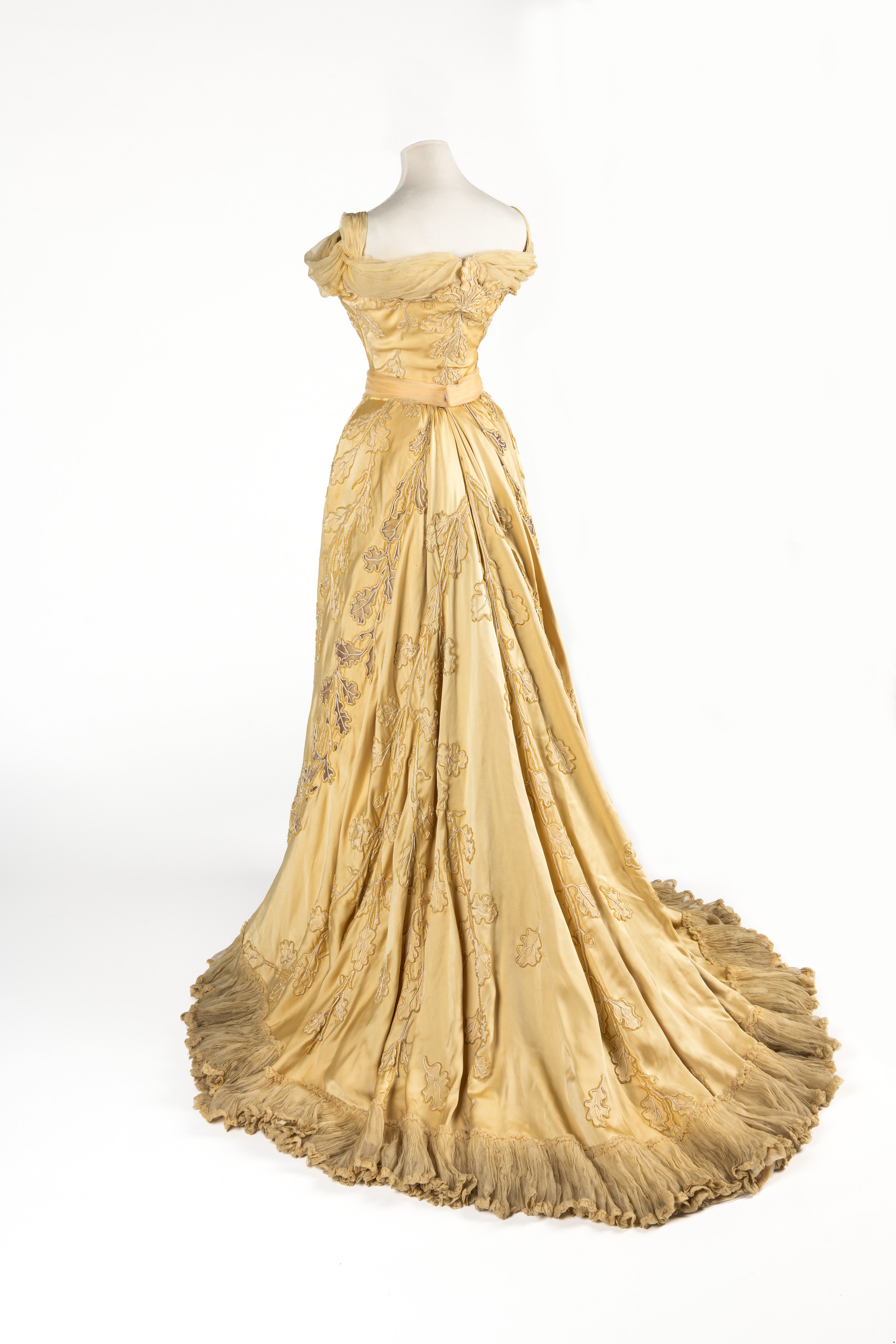 Yellow silk evening dress with oakleaf motif embroidered in cream silk cord and chenille, by Worth, worn by Lady Curzon, Vicereine of India, ca.1903