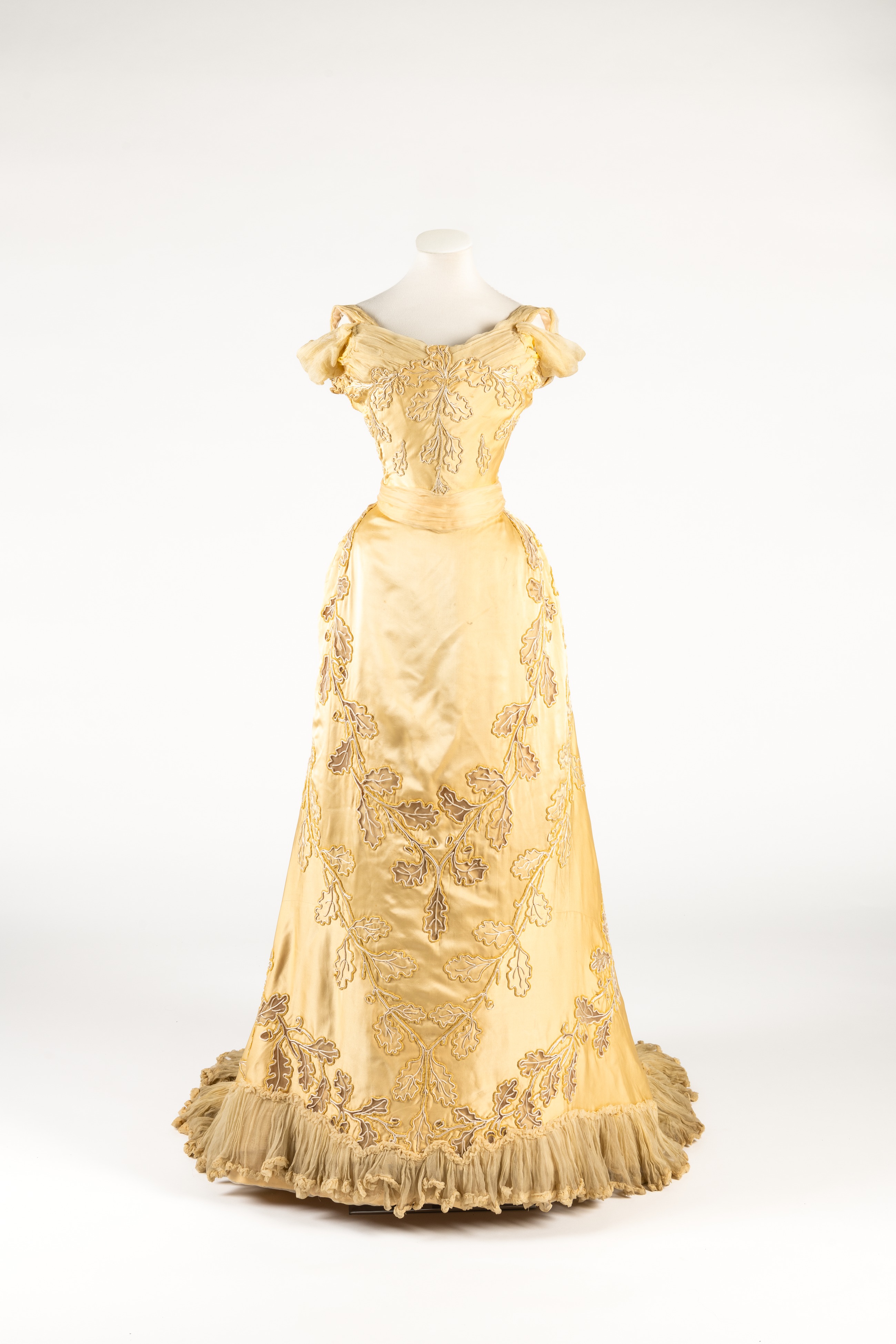 Yellow silk evening dress with oakleaf motif embroidered in cream silk cord and chenille, by Worth, worn by Lady Curzon, Vicereine of India, ca.1903
