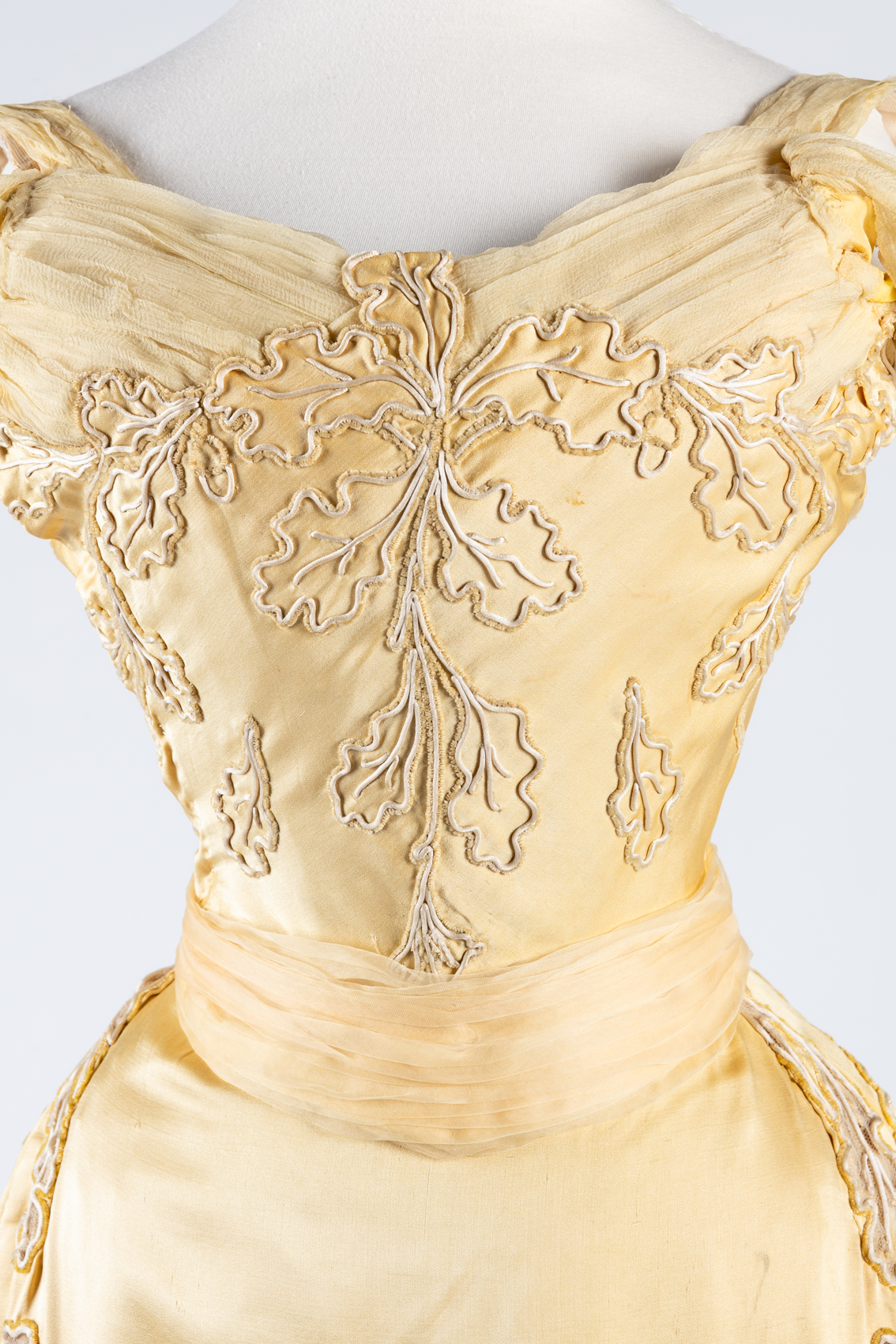 Yellow silk evening dress with oakleaf motif embroidered in cream silk cord and chenille, by Worth, worn by Lady Curzon, Vicereine of India, ca.1903