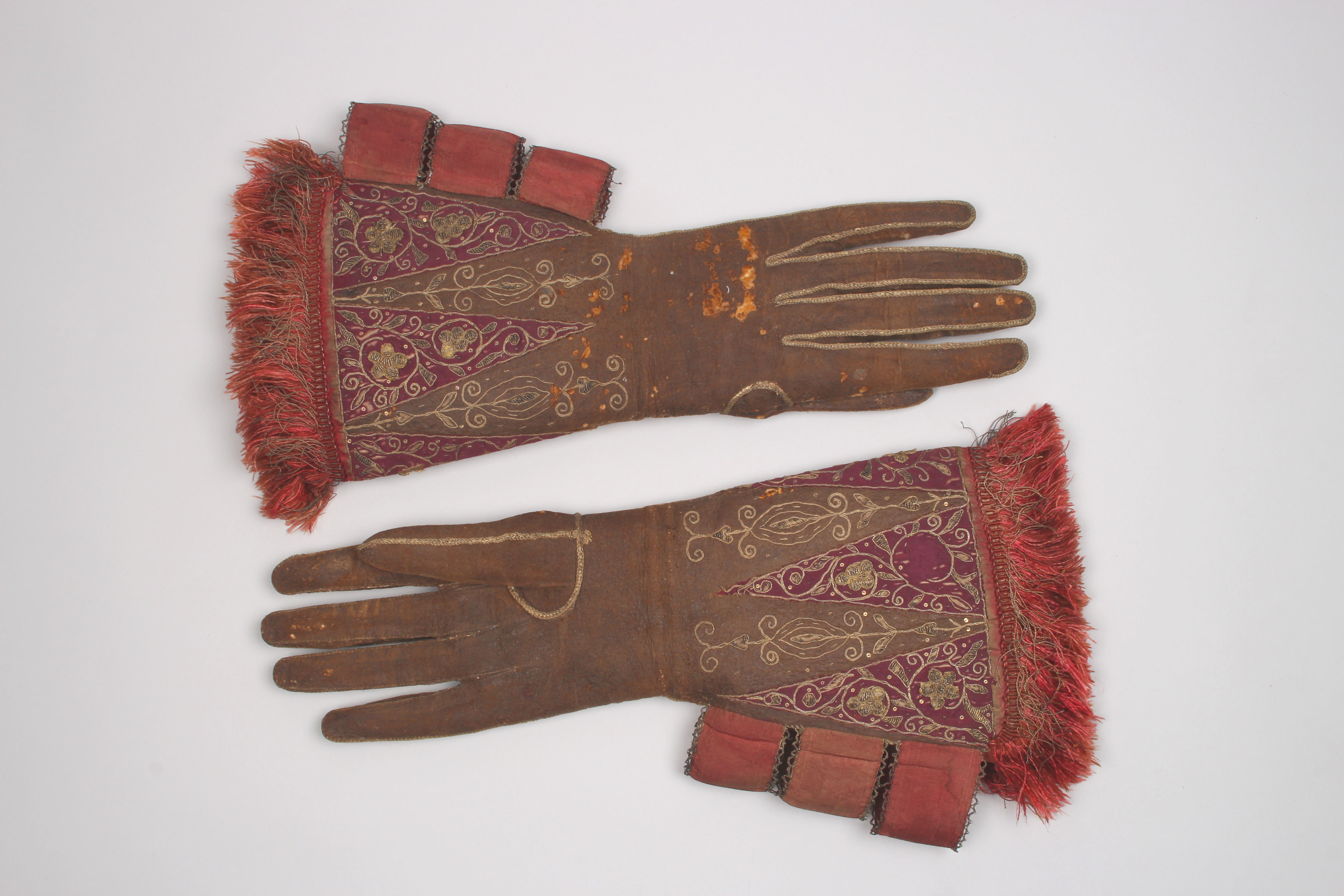 Brown leather gloves with red silk embroidery and embellishment belonging to King James I, 1610s