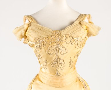 A yellow silk evening gown embroidered with an oak leaf design is on display in The House of Worth: Inventing Haute Couture at petit Palais, Paris, in collaboration with Galliera, Paris