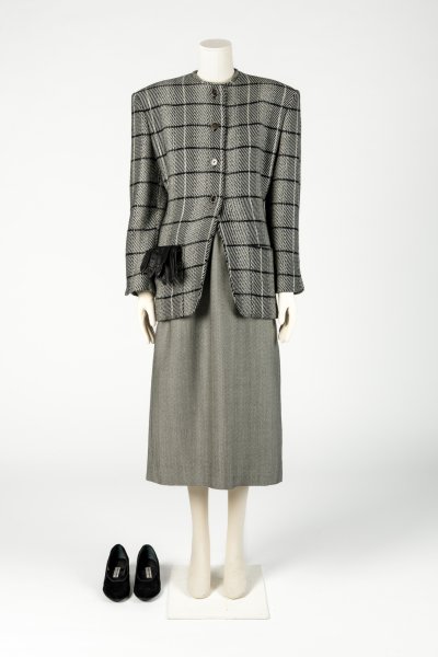 Woman’s grey checked wool jacket and skirt worn with black suede shoes